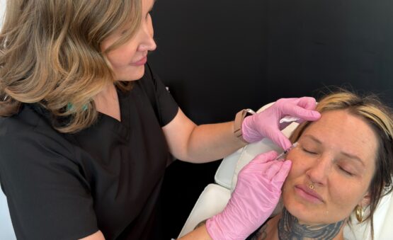 Provider administering Botox injections to a patient during an aesthetic treatment.