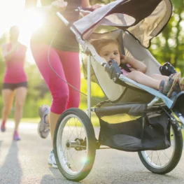 mom running behind a running stroller with child