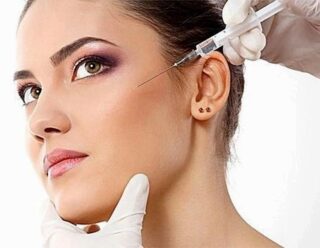 doctor injecting botox into beautiful woman's face