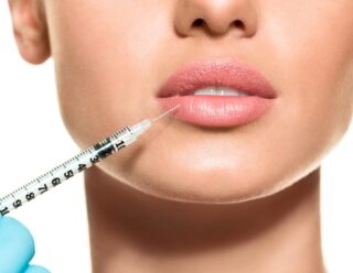 doctor inserting lip fillers into woman's lips